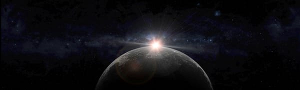 The sun setting behind the moon